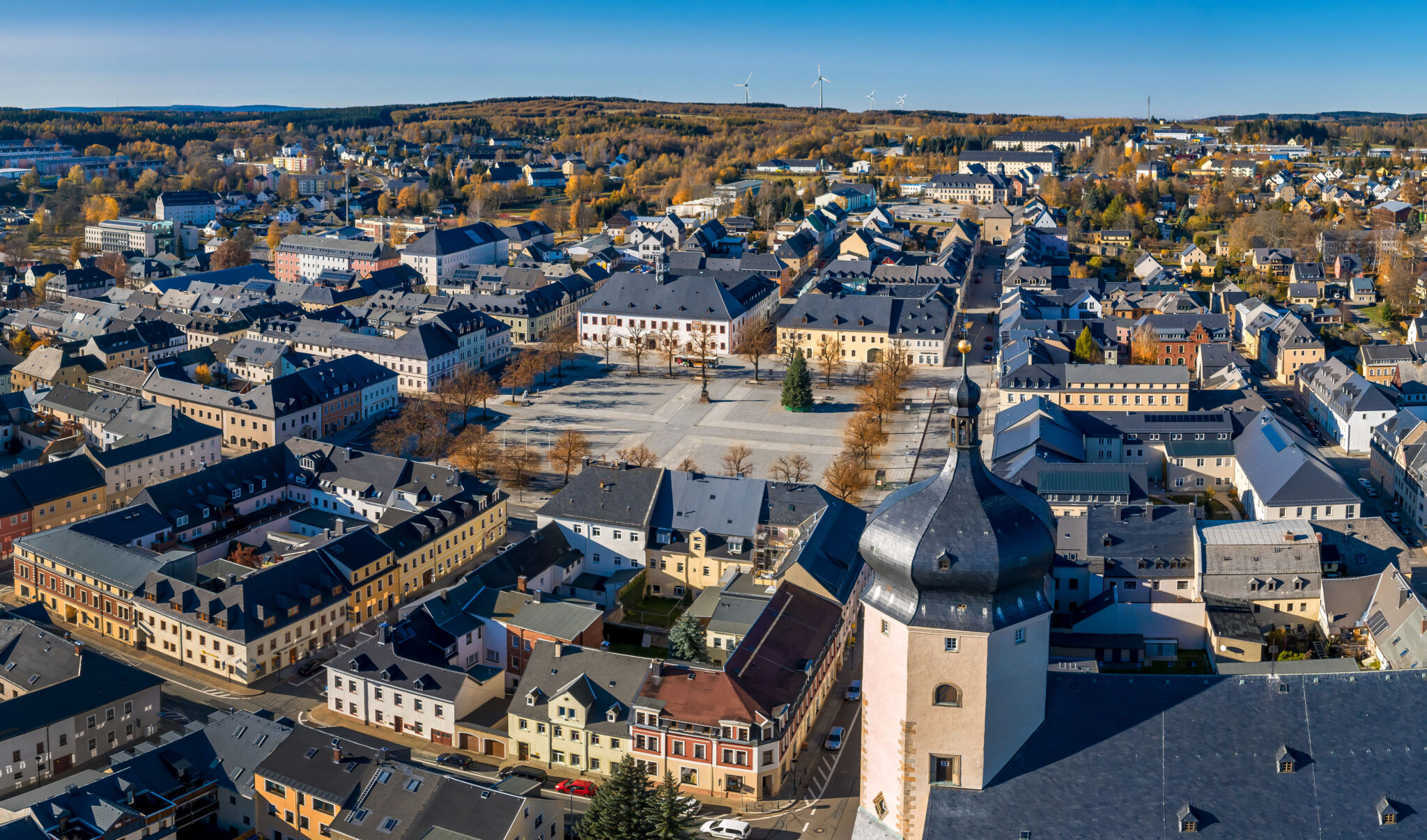 Luftbild der Bergstadt Marienberg mit Blick auf die Altstadt und den Marktplatz, umgeben von herbstlichen Bäumen.