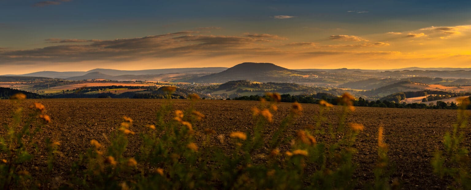 Panorama des Sonnenuntergangs über dem Pöhlberg, Fichtelberg und Keilberg, aufgenommen vom Flugplatz Großrückerswalde.