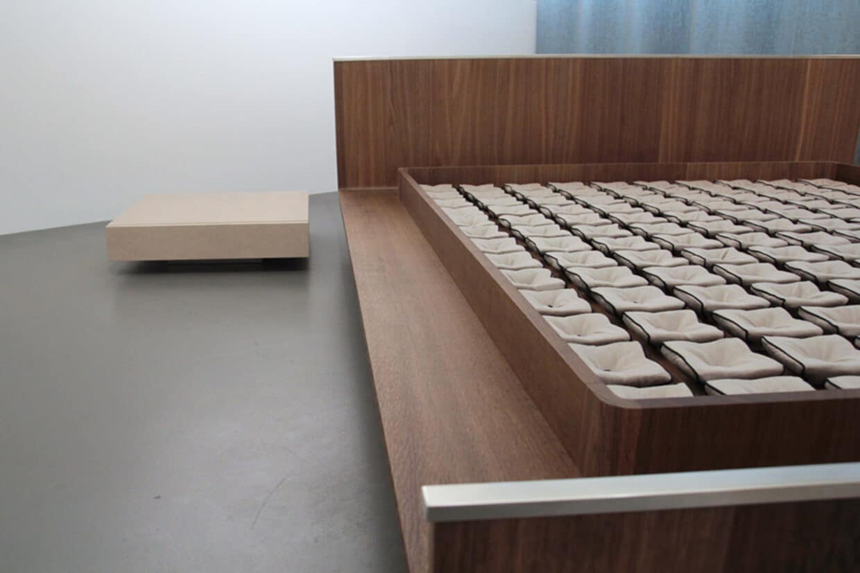 Möbelstücke nr 5 - Deutsche Manufakturenstrasse Blick unter die Matratze eines Bettes mit 130 Leinen bezogenen Tellerrosten, Holzrahmen im Vordergrund.