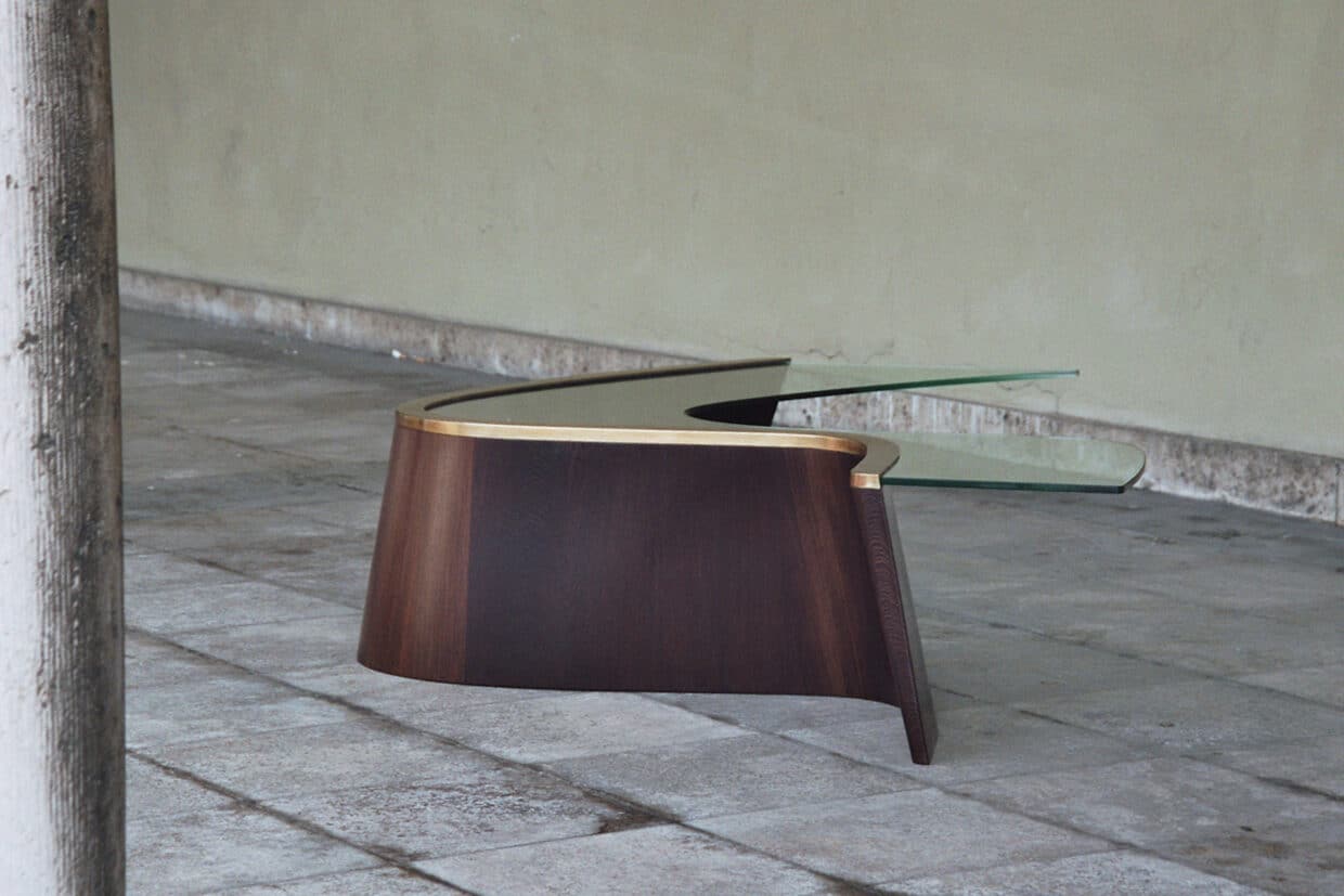 Möbelstücke nr 6 - Deutsche Manufakturenstrasse Objekttisch aus Wenge mit Messingkante und Glasplatte, in einem minimalistischen Raum auf Fliesenboden.