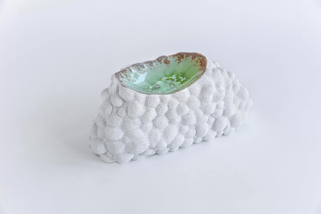 wachsen - Deutsche Manufakturenstrasse Skulptur in Form eines organischen Objekts mit einer strukturierten, grauen Oberfläche und einer glasierten, mintgrünen ...