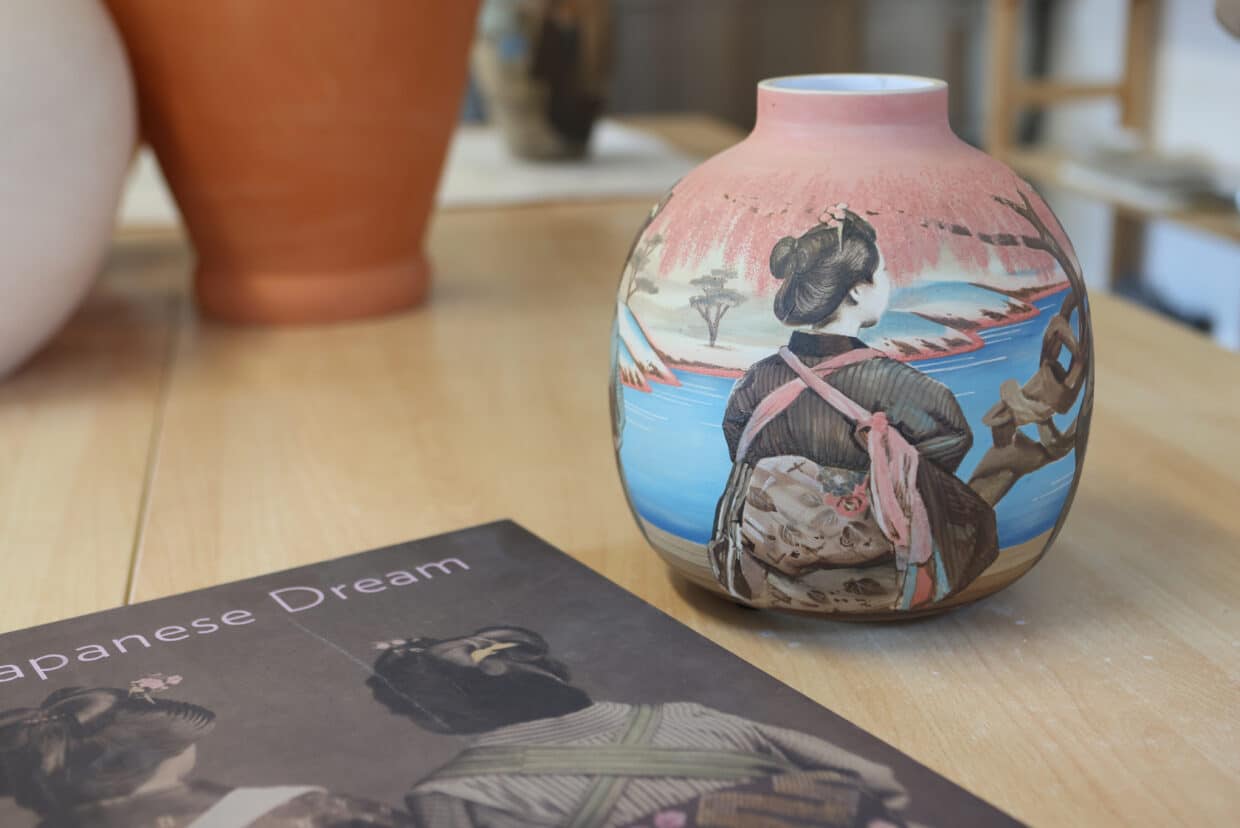 10_Victoria_Tobostai2025_075 - Deutsche Manufakturenstrasse Vase mit japanischem Motiv auf einem Tisch, daneben ein Buch mit dem Titel "Japanese Dream".