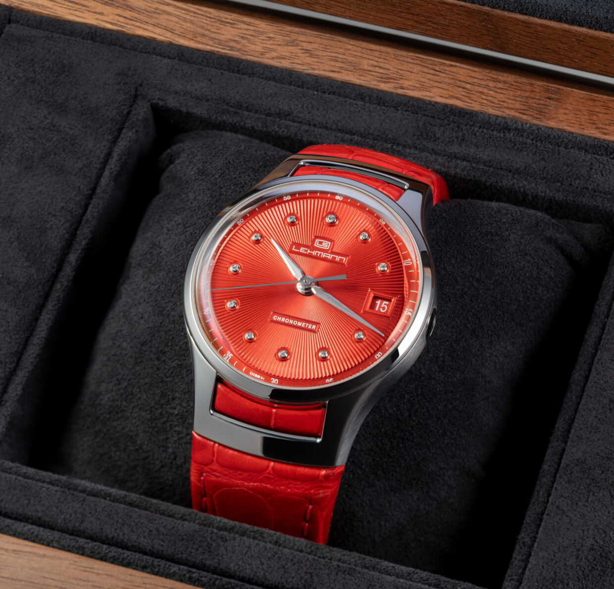 Rote Lehmann-Uhr mit glänzendem Ziffernblatt und Diamanten, in einer eleganten Box präsentiert.