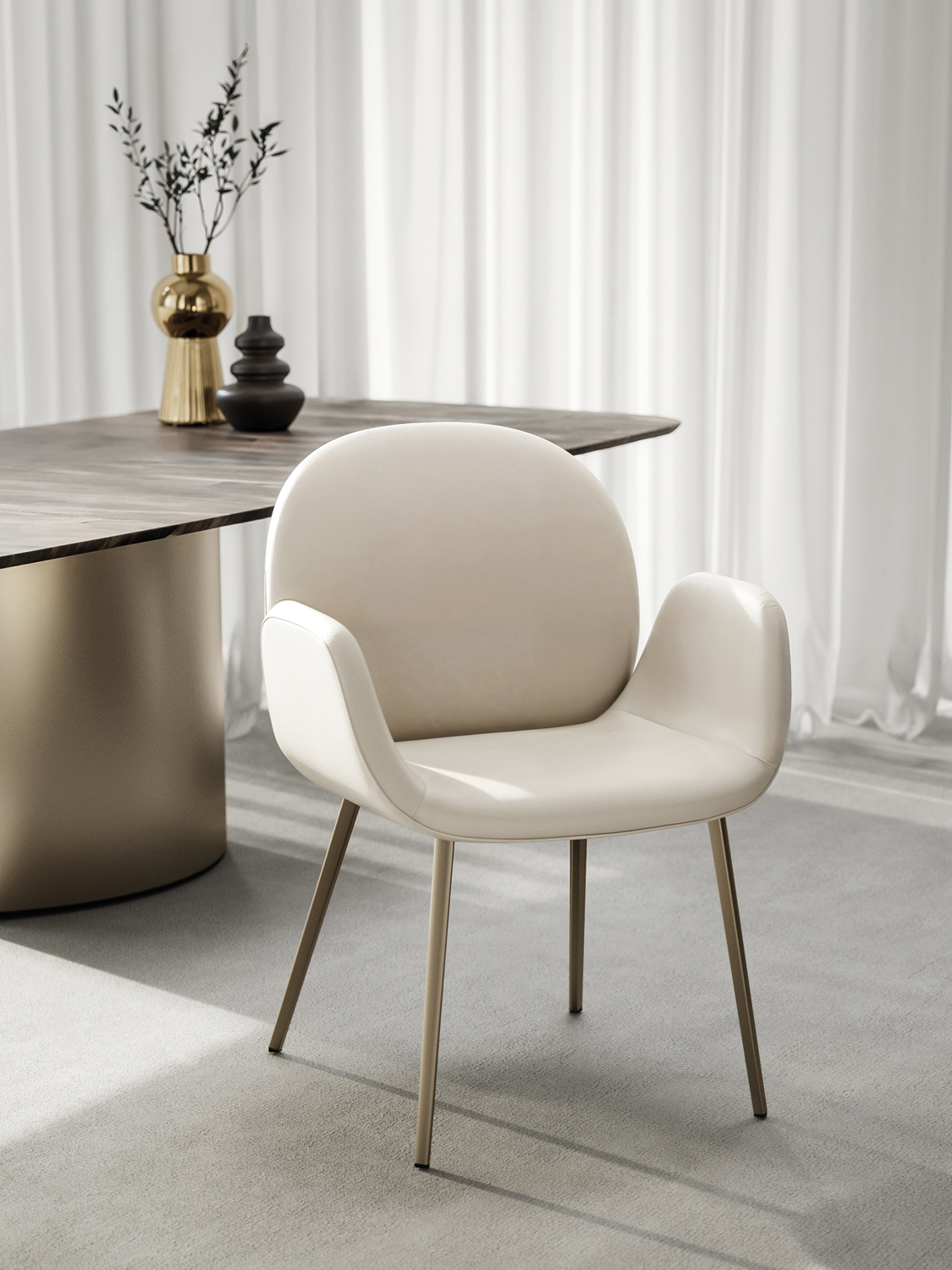 01_DRAENERT_COBE-mit-Armlehnen_01 - Deutsche Manufakturenstrasse Eleganter, beiger Stuhl mit Armlehnen vor einem modernen Tisch und dekorativen Vasen in einem hellen Raum.