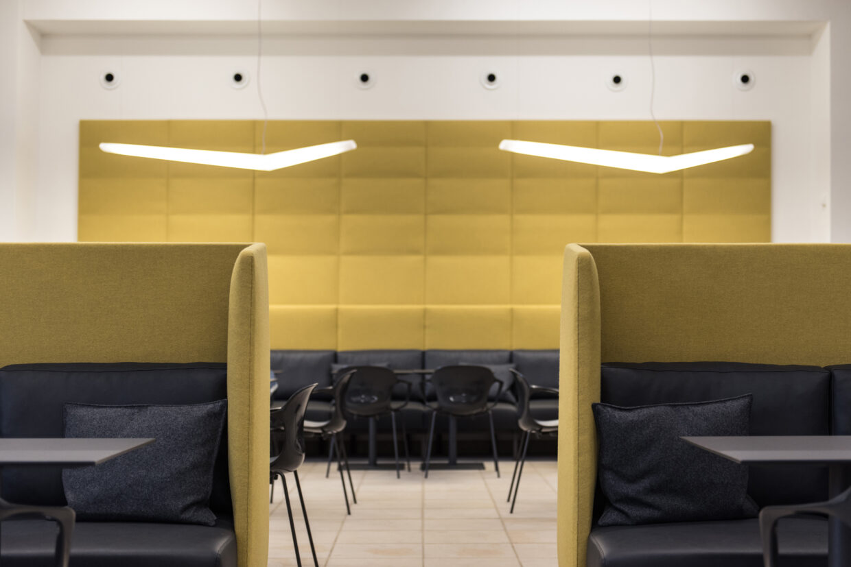 DSC_2179 - Deutsche Manufakturenstrasse Moderne Café-Innenansicht mit gelben Akustikpaneelen, schwarzen Stühlen und gemütlichen Sitznischen.