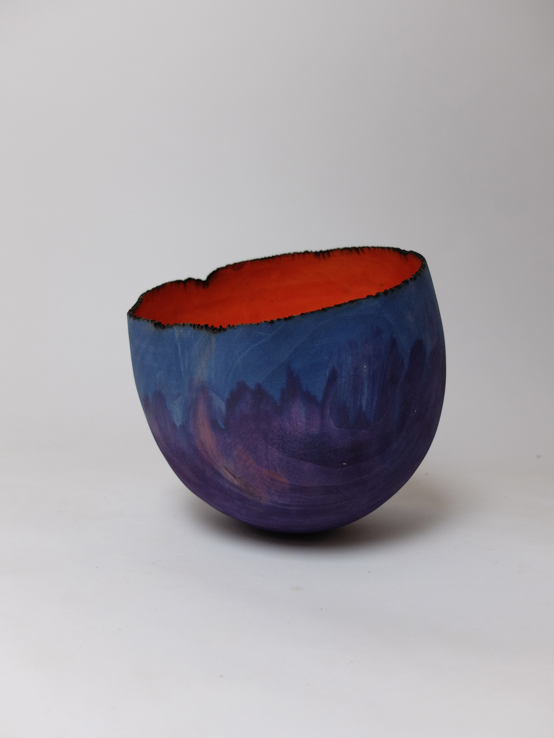 objekt5 - Deutsche Manufakturenstrasse Schale mit unregelmäßigem Rand, außen lila und innen orange, auf hellem Hintergrund.