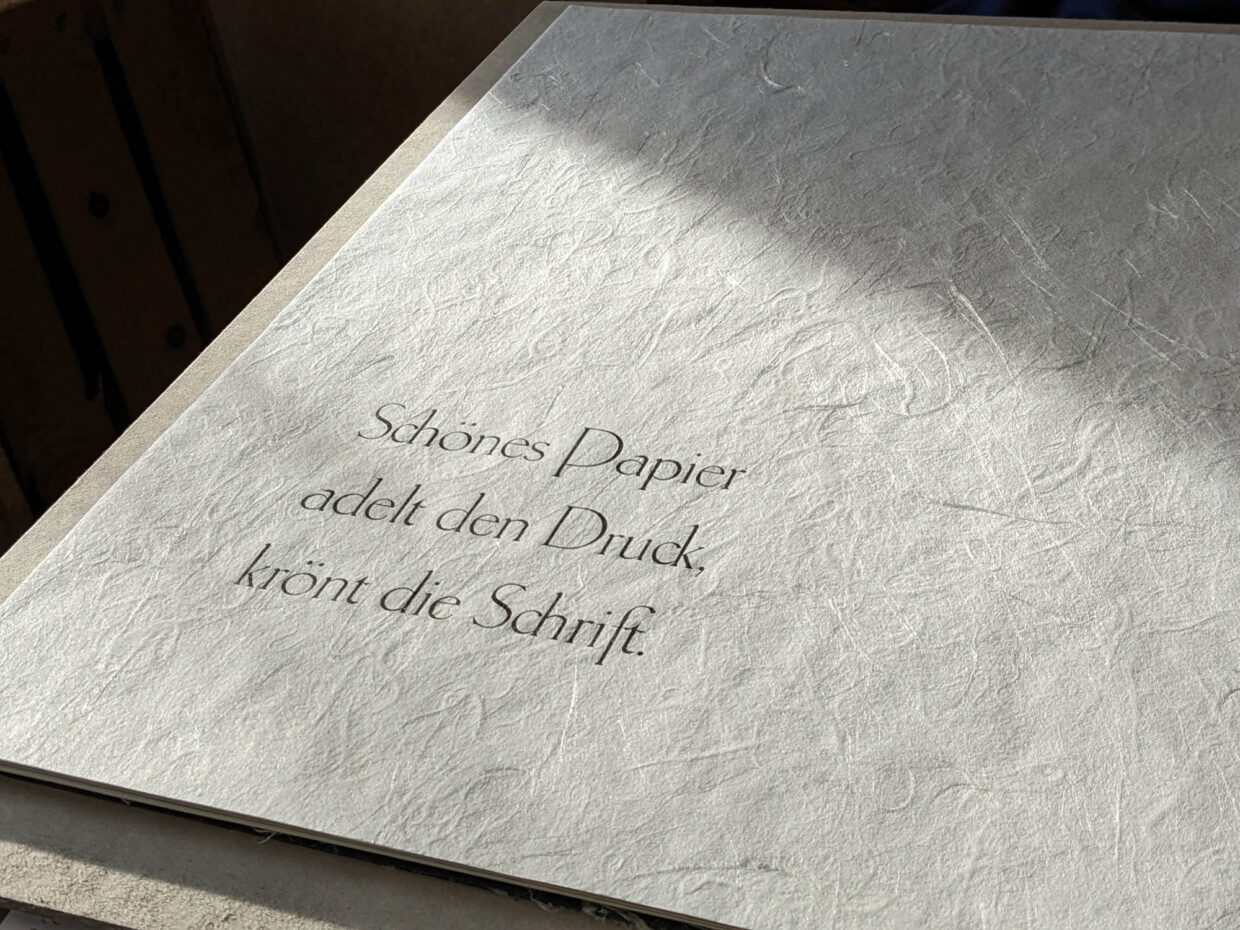 Druckprozess - Deutsche Manufakturenstrasse Text auf strukturiertem Papier: "Schönes Papier adelt den Druck, krönt die Schrift.