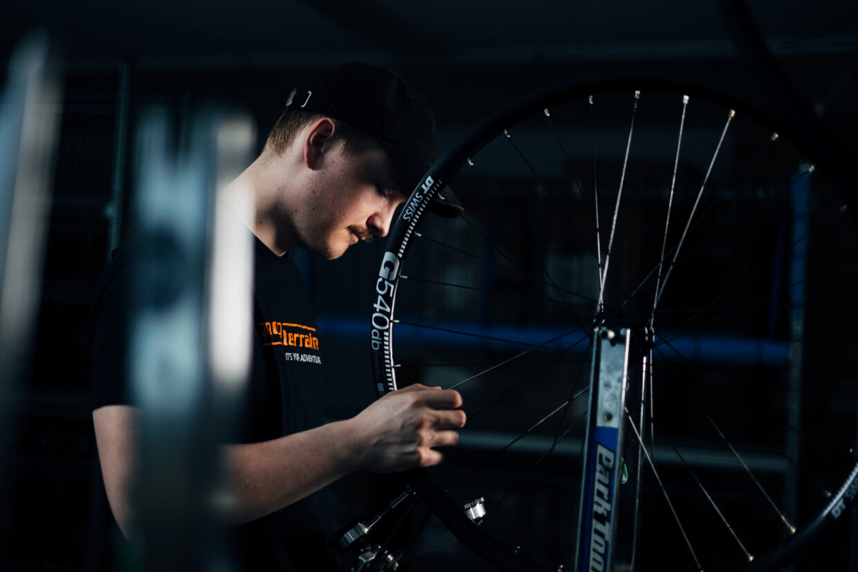 240508_JJANK_ToutTerrain_ManufakturShoot-03817 - Deutsche Manufakturenstrasse Mitarbeiter bei Tout Terrain montiert sorgfältig ein Fahrradrad in der Manufaktur.