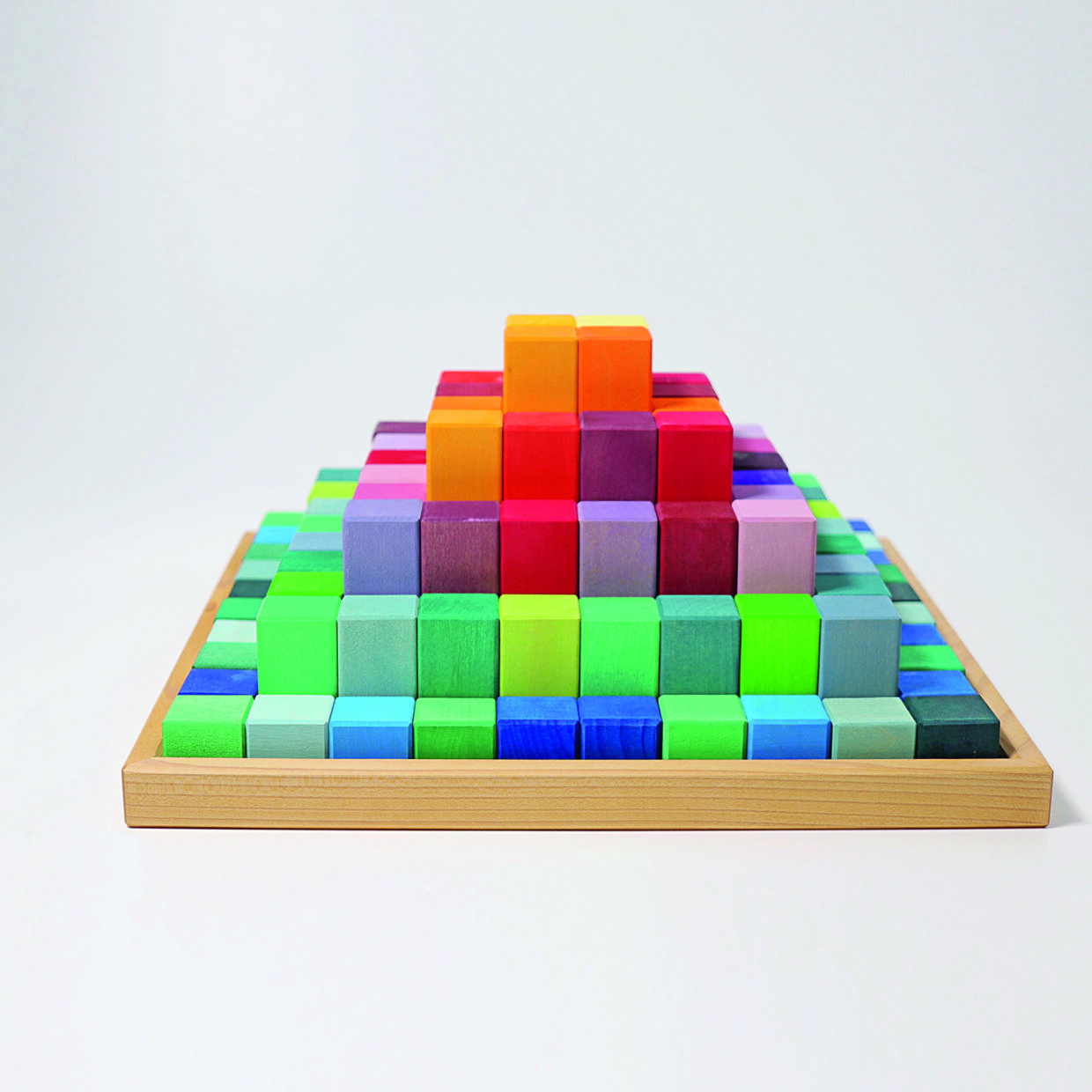42090_Grosse_Stufenpyramide_v1 1 - Deutsche Manufakturenstrasse Bunte Holzbausteine in Form einer Stufenpyramide auf einem Holzbrett, angeordnet in verschiedenen Farben.