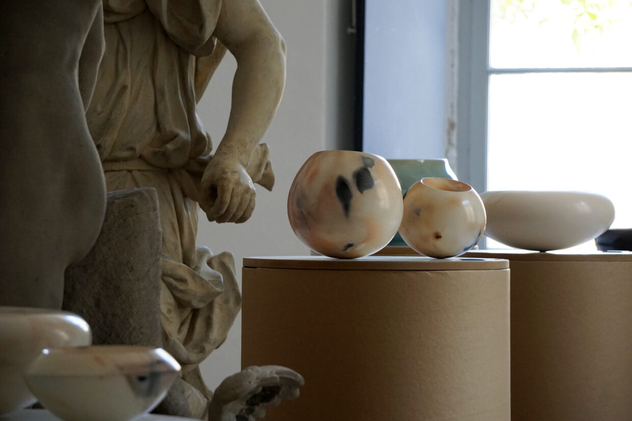 Ausstellung Lapidarium Schloss Ludwigsburg 1 - Deutsche Manufakturenstrasse Zwei dekorative Vasen aus Alabaster auf runden Podesten, umgeben von Skulpturen in der Ausstellung Lapidarium im Schloss L...