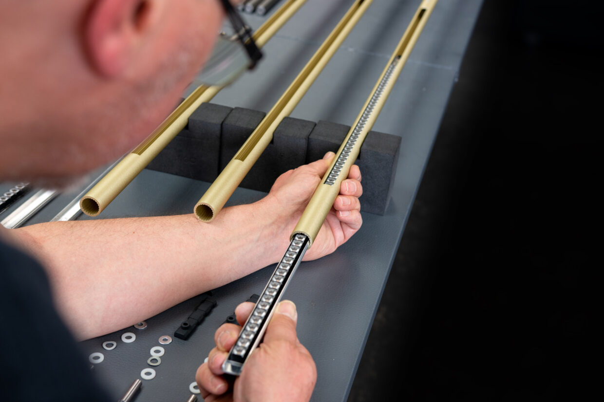 DETAILS-SATTLER-PRODUKTION_PALITO_Pendelleuchte_Handmontage_2 1 - Deutsche Manufakturenstrasse Handmontage einer Pendelleuchte mit Fokus auf die präzise Bearbeitung von Metallrohren und Befestigungselementen.