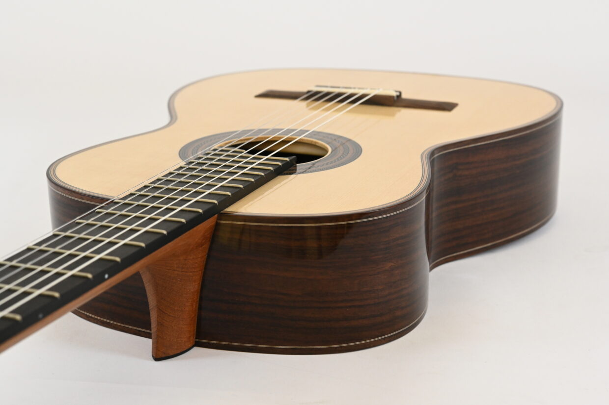 DSC_3339 1 - Deutsche Manufakturenstrasse Akustische Gitarre mit hellem Zargen- und Bodenholz, sichtbarem Griffbrett und Schallloch.