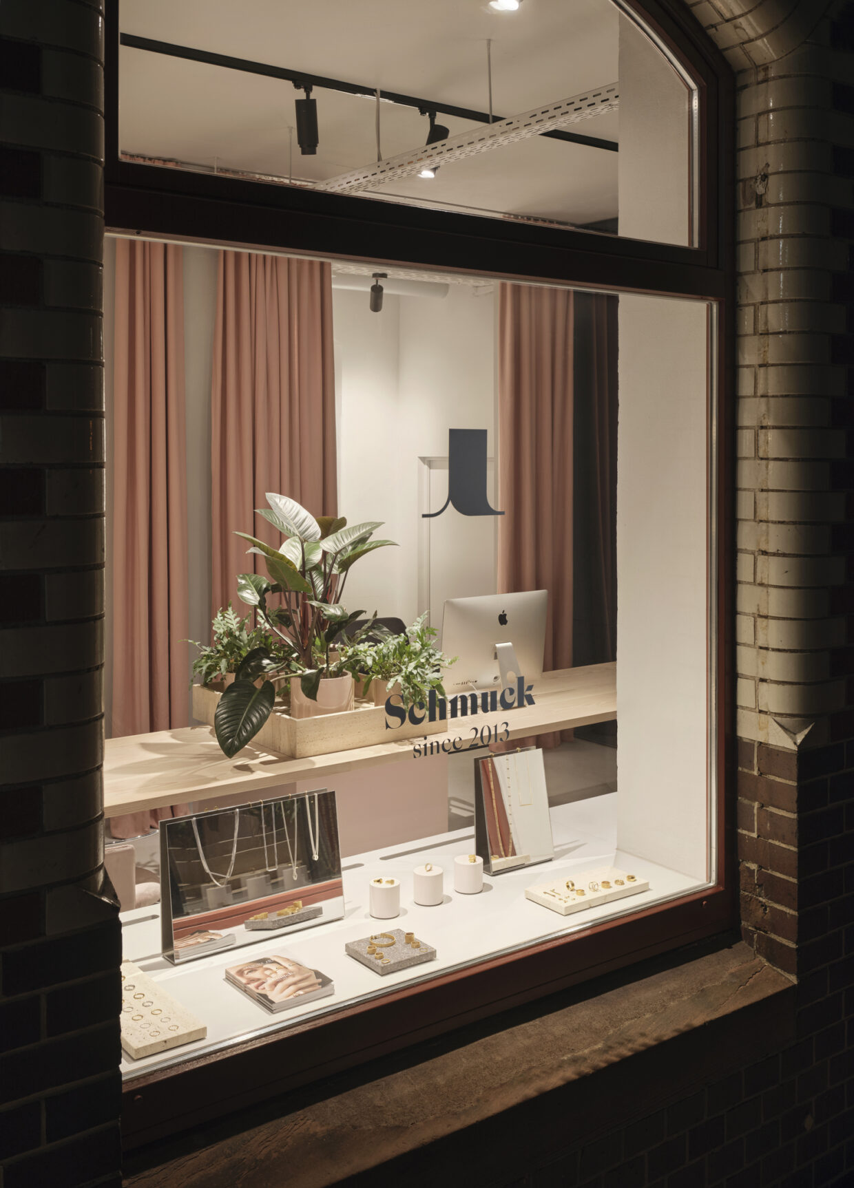 JJ_Showroom-Manufaktur_Feb2023_2232_glatt_A - Deutsche Manufakturenstrasse Schaufenster eines Schmuckgeschäfts mit Pflanzen, einem Computer und Auslagen für Schmuckstücke.