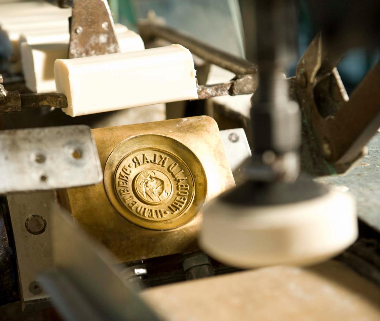 KS_Form_pressen_05_preview - Deutsche Manufakturenstrasse Seifenform mit eingraviertem Logo auf einer Produktionsmaschine in der Seifenherstellung.