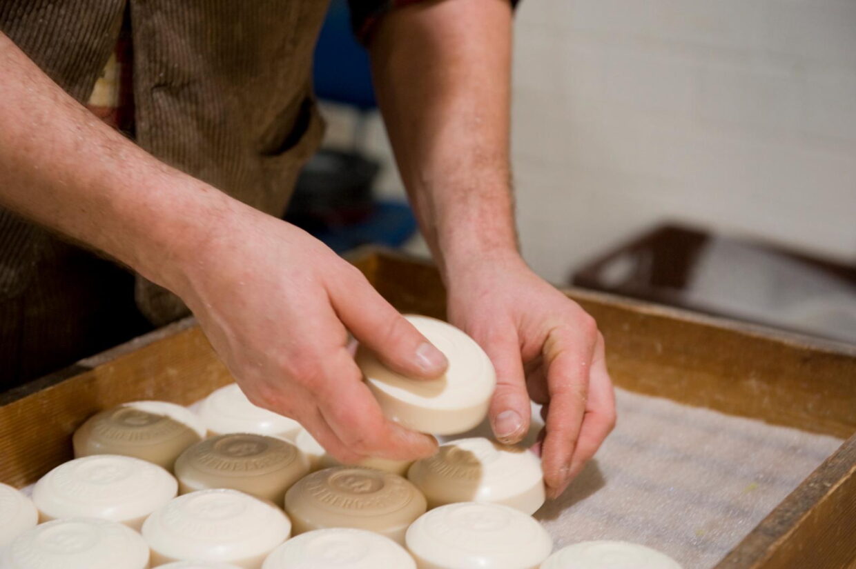 KS_Produktion_Handarbeit_07_preview - Deutsche Manufakturenstrasse Hände legen handgefertigte Seifenstücke in eine Holzkiste. Kontext: Klar Seifen Produktion.