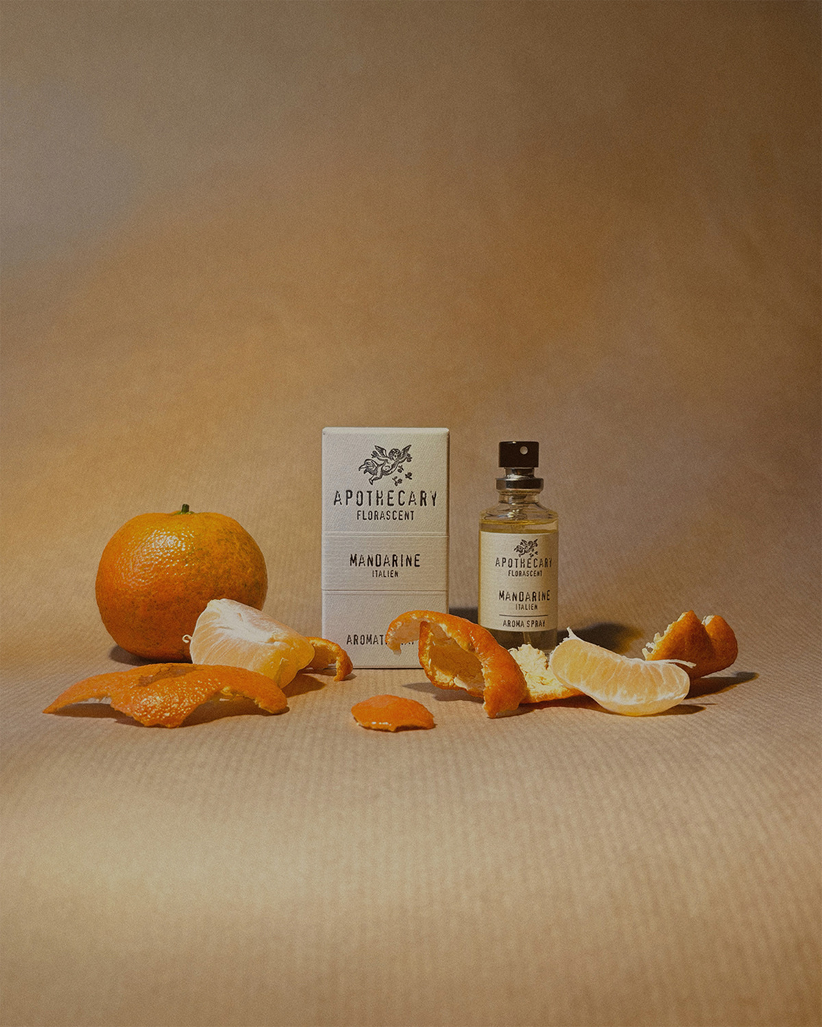 Mandarine_apo_30 - Deutsche Manufakturenstrasse Mandarinenfrucht, Schalen und Flasche mit ätherischem Mandarinenöl auf braunem Hintergrund.