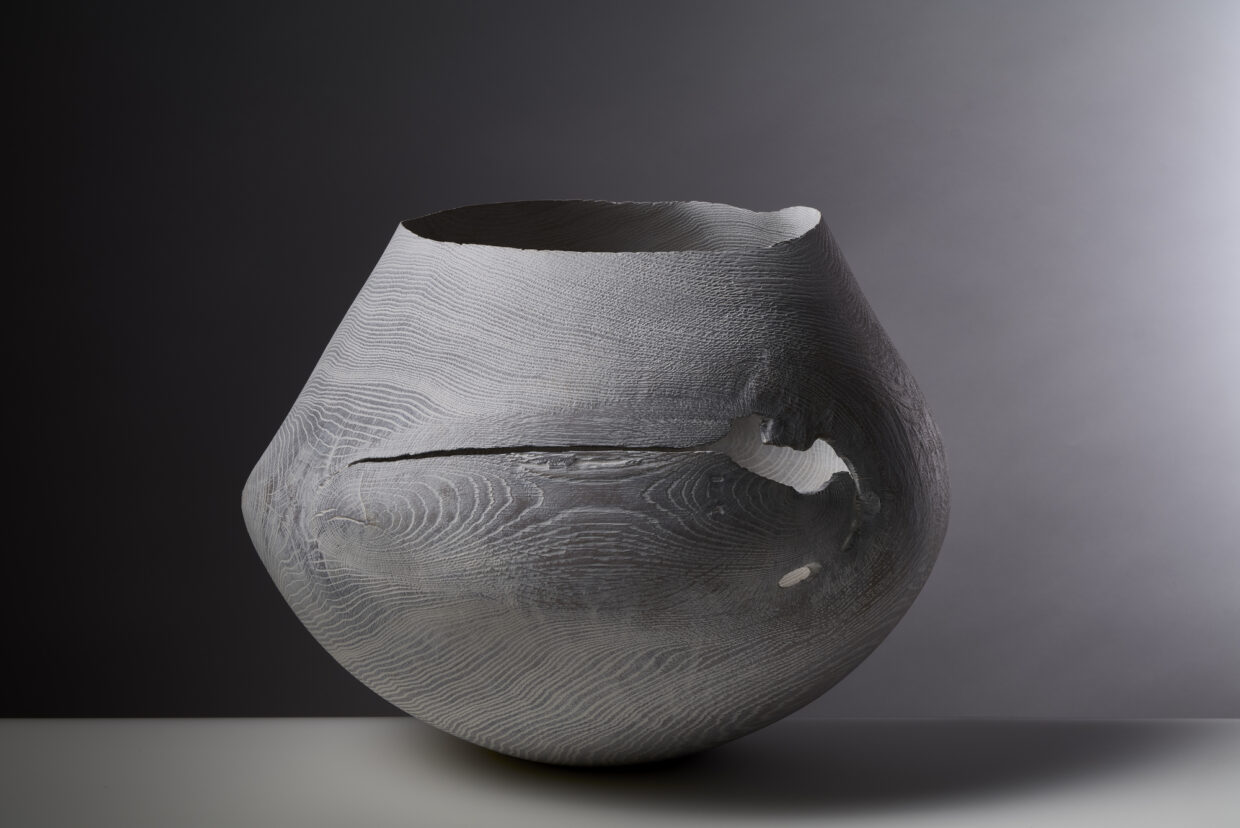 WLO 119 1 - Deutsche Manufakturenstrasse Holzgefäß mit geschwungener Form und sichtbarer Maserung, auf einem neutralen Hintergrund beleuchtet.